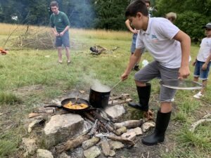 Un enfant du cours Guillaumet apprend la cuisine au feu de bois